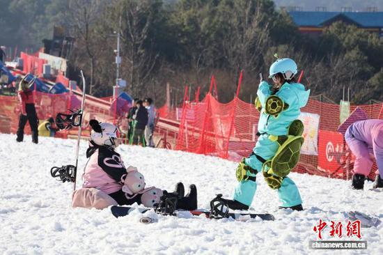 图为2月9日，游客在六盘水市玉舍雪山滑雪场拍照。中新网记者 刘美伶 摄