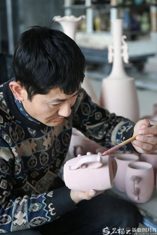 2月8日，工人托合提巴拉提·阿不杜海拜尔在新疆昆仑玉瓷科技文化有限公司车间为玉瓷制品进行涂油工艺作业。