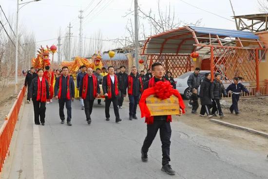 敲锣打鼓为博士家庭送“博士之家”牌匾。 胡礼政 摄