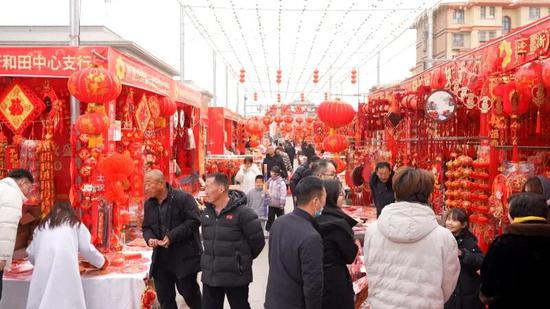 群众在年货街选购春联、挂件等节日饰品。阿卜力克木·依卜拉依木 摄