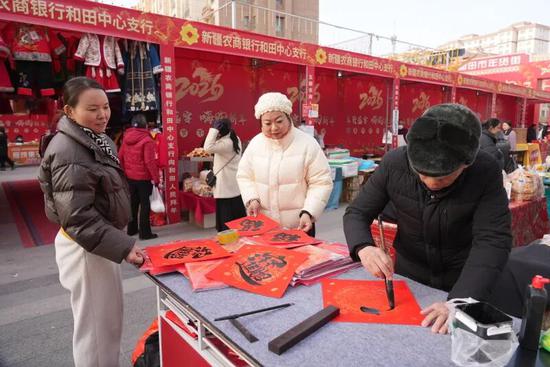 商家为市民现场写福。阿卜力克木·依卜拉依木 摄