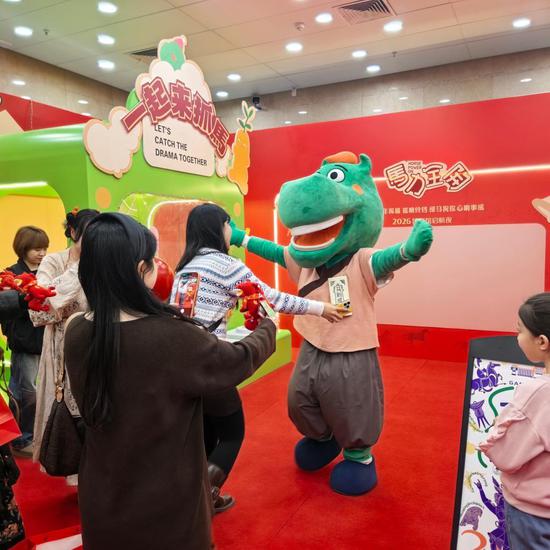 甘肃省博物馆内的“抓马”市集里，年轻游客排队争相与“绿马”人偶合影留念。新华社记者李杰 摄