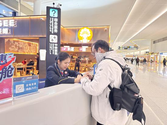 3962287149b61636f0b9f0db755437a1王元元为中转旅客办理值机手续 米亚 摄
