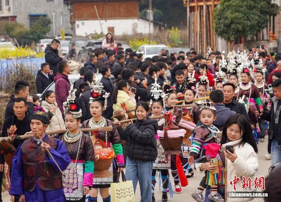 2月18日，贵州省黔东南苗族侗族自治州从江县贯洞镇干团村的侗族同胞举行“鼓楼抢鸡”传统民俗活动，热热闹闹庆新春。“鼓楼抢鸡”是干团村保留的一种古老婚俗，这种以娱乐形式调解婚姻矛盾的侗族民俗，现已演绎成一项精彩纷呈的传统节庆活动。图为侗族同胞正前往鼓楼。卢忠南 摄