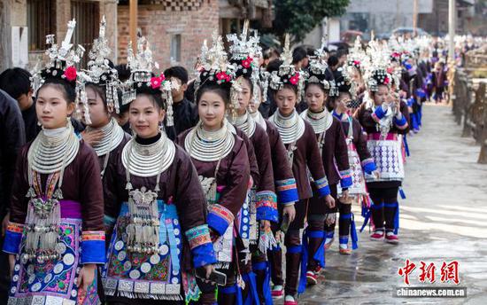 春节期间,贵州省黔东南苗族侗族自治州从江县西山镇顶洞村,侗族同胞身着民族盛装欢聚一堂,通过踩歌堂、盛装巡游、侗歌对唱等传统习俗,欢庆新春佳节。图为侗族同胞盛装巡游。罗京来 摄 春节期间,贵州省黔东南苗族侗族自治州从江县西山镇顶洞村,侗族同胞身着民族盛装欢聚一堂,通过踩歌堂、盛装巡游、侗歌对唱等传统习俗,欢庆新春佳节。图为侗族同胞盛装巡游。罗京来 摄