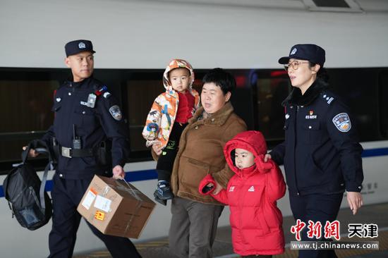 图为齐玮与乘警在站台上帮助旅客运送行李,并保障儿童上车安全。(北京铁路公安局天津公安处供图)