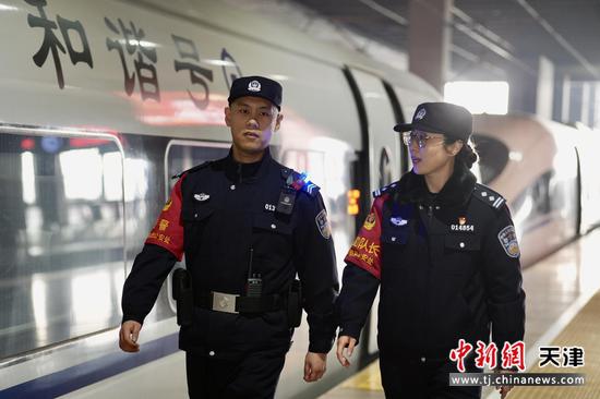 图为齐玮与一线乘警共同在站台上检查列车车体,保证列车安全。(北京铁路公安局天津公安处供图)