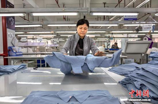 图为2月24日,工人在贵州省黔西市经济开发区一家服饰企业车间对产品进行质检。史开心 摄 图为2月24日,工人在贵州省黔西市经济开发区一家服饰企业车间对产品进行质检。史开心 摄