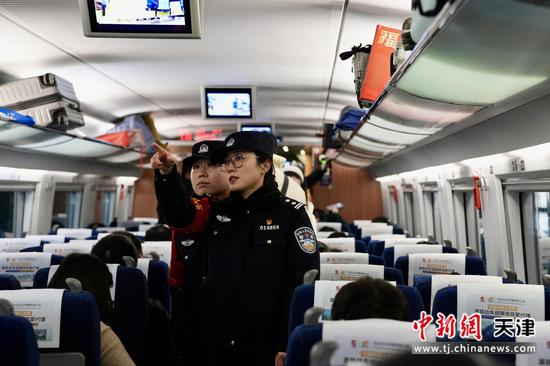 图为列车开车后,齐玮与乘警在车厢内开展巡视工作,检查安全隐患。(北京铁路公安局天津公安处供图)