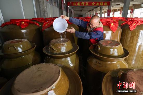 2月25日,贵州省黔南州龙里县一家辣椒加工企业生产车间,工人在给糟辣椒存储坛加水。春节假期过后,龙里县众多工业企业复工生产,加紧赶制各类订单产品保障市场供应,生产车间内一派繁忙景象。中新社记者 瞿宏伦 摄 2月25日,贵州省黔南州龙里县一家辣椒加工企业生产车间,工人在给糟辣椒存储坛加水。春节假期过后,龙里县众多工业企业复工生产,加紧赶制各类订单产品保障市场供应,生产车间内一派繁忙景象。中新社记者 瞿宏伦 摄