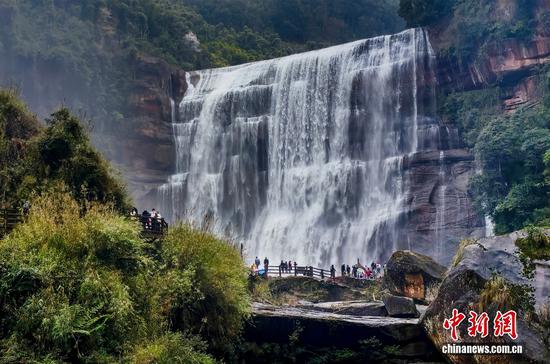 2026年2月23日，贵州遵义赤水丹霞大瀑布气势磅礴，丹霞赤壁与飞瀑流泉相映成趣，吸引各地游客前来赏瀑观景，在山水间尽享自然之美，感受丹霞瀑布的独特魅力。