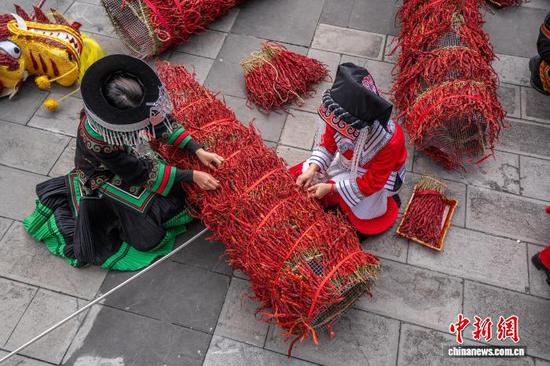 图为民众用皱椒串起龙头龙身。李安连 摄 图为民众用皱椒串起龙头龙身。李安连 摄