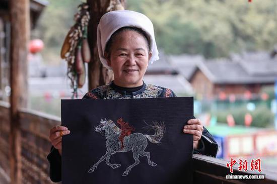 3月1日，韦桃花在展示“贵州村马”系列马尾绣作品。水族马尾绣是贵州省黔南州三都水族自治县水族妇女世代传承的一种特殊刺绣技艺，被称为中国刺绣的“活化石”。马尾绣以丝线缠裹马尾并盘在描绘好的花纹轮廓上，再根据轮廓线绣出各种图案，工艺独特、复杂。62岁的韦桃花从小学习马尾绣制作技艺，是中国国家级非物质文化遗产水族马尾绣代表性传承人。50多年来，韦桃花在研究和继承传统马尾绣制作方法的基础上大胆创新，在图案设计、刺绣等工艺方面形成自己独有的制作风格，创作出一批精美独特的马尾绣作品深受消费者喜爱。中新社记者 瞿宏伦 摄