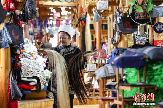 3月1日，韦桃花在整理马尾。水族马尾绣是贵州省黔南州三都水族自治县水族妇女世代传承的一种特殊刺绣技艺，被称为中国刺绣的“活化石”。马尾绣以丝线缠裹马尾并盘在描绘好的花纹轮廓上，再根据轮廓线绣出各种图案，工艺独特、复杂。62岁的韦桃花从小学习马尾绣制作技艺，是中国国家级非物质文化遗产水族马尾绣代表性传承人。50多年来，韦桃花在研究和继承传统马尾绣制作方法的基础上大胆创新，在图案设计、刺绣等工艺方面形成自己独有的制作风格，创作出一批精美独特的马尾绣作品深受消费者喜爱。中新社记者 瞿宏伦 摄