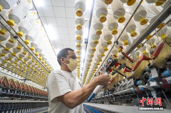 图为贵州省毕节高新区轻纺城内的一家纺织企业车间，工人正在生产线上作业。李安连 摄