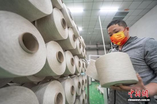 图为贵州省毕节高新区轻纺城内的一家纺织企业车间，工人正在生产线上作业。李安连 摄