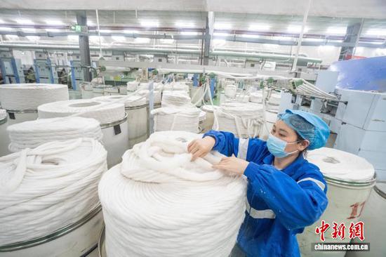 图为贵州省毕节高新区轻纺城内的一家纺织企业车间，工人正在生产线上作业。李安连 摄