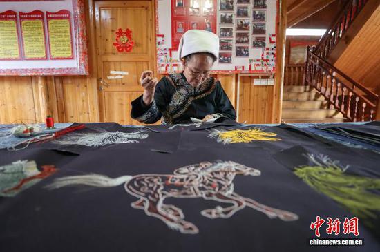 3月1日，韦桃花在缝制马尾绣作品。水族马尾绣是贵州省黔南州三都水族自治县水族妇女世代传承的一种特殊刺绣技艺，被称为中国刺绣的“活化石”。马尾绣以丝线缠裹马尾并盘在描绘好的花纹轮廓上，再根据轮廓线绣出各种图案，工艺独特、复杂。62岁的韦桃花从小学习马尾绣制作技艺，是中国国家级非物质文化遗产水族马尾绣代表性传承人。50多年来，韦桃花在研究和继承传统马尾绣制作方法的基础上大胆创新，在图案设计、刺绣等工艺方面形成自己独有的制作风格，创作出一批精美独特的马尾绣作品深受消费者喜爱。中新社记者 瞿宏伦 摄