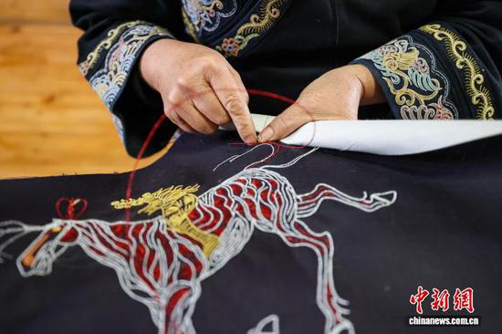 3月1日，韦桃花缝制的马尾绣作品。水族马尾绣是贵州省黔南州三都水族自治县水族妇女世代传承的一种特殊刺绣技艺，被称为中国刺绣的“活化石”。马尾绣以丝线缠裹马尾并盘在描绘好的花纹轮廓上，再根据轮廓线绣出各种图案，工艺独特、复杂。62岁的韦桃花从小学习马尾绣制作技艺，是中国国家级非物质文化遗产水族马尾绣代表性传承人。50多年来，韦桃花在研究和继承传统马尾绣制作方法的基础上大胆创新，在图案设计、刺绣等工艺方面形成自己独有的制作风格，创作出一批精美独特的马尾绣作品深受消费者喜爱。中新社记者 瞿宏伦 摄