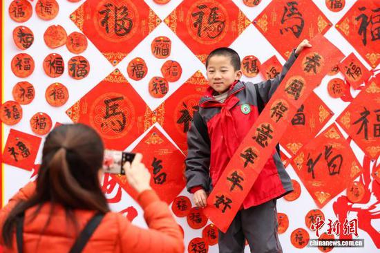 3月2日，贵州省黔南布依族苗族自治州贵定县第一小学组织丰富多彩、形式多样的开学活动，让学生们在欢声笑语中迎接新学期。图为一名小学生在展示自己写的春联。中新社记者 瞿宏伦 摄