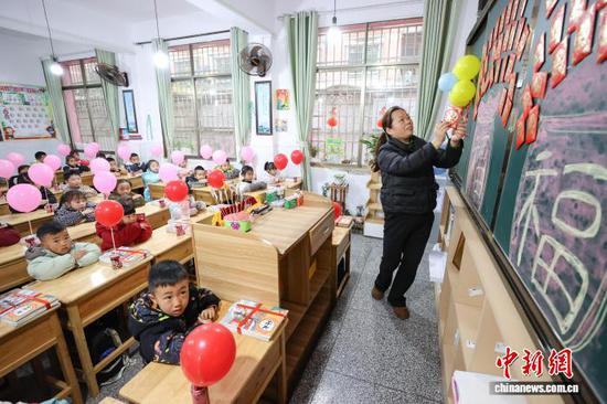 图为一位老师在给学生展示活动奖励。中新社记者 瞿宏伦 摄