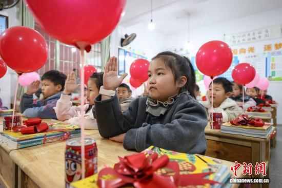 图为小学生在课堂上向老师举手示意。中新社记者 瞿宏伦 摄