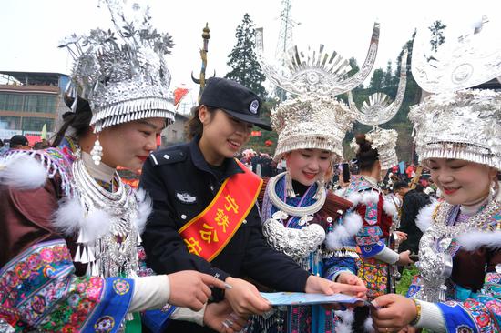 图为民警在坡会现场发放宣传资料,讲解乘车安全知识与反诈防骗技巧。 夏阳春 摄 图为民警在坡会现场发放宣传资料,讲解乘车安全知识与反诈防骗技巧。 夏阳春 摄