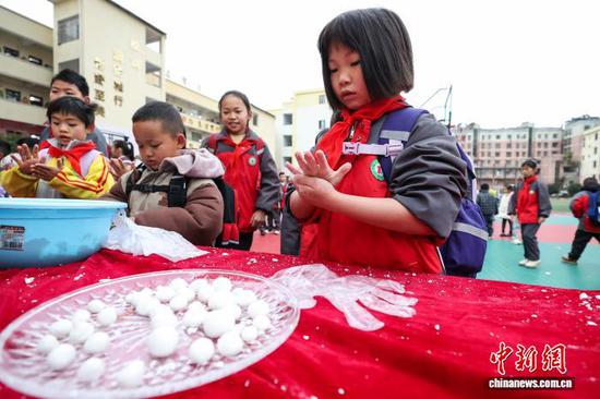 图为小学生在参与包汤圆。中新社记者 瞿宏伦 摄