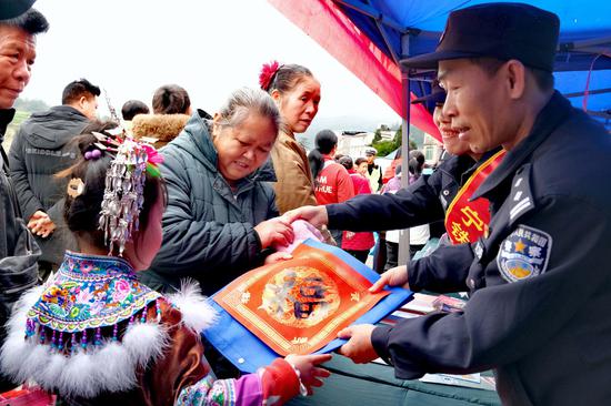 图为民警周奋勇坡会现场书写“安太十三坡,福气满山坡”,并与苗族群众合影。夏阳春 摄 图为民警周奋勇坡会现场书写“安太十三坡,福气满山坡”,并与苗族群众合影。夏阳春 摄