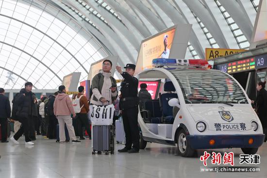 图为北京铁路公安局天津公安处天津西站派出所民警解答一名旅客的求助。（北京铁路公安局天津公安处供图）