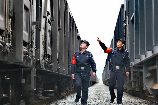 图为民警在线路进行治安巡查，对停站货物列车进行检查。 夏阳春 摄