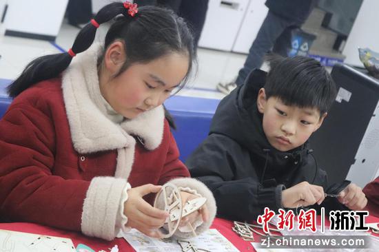 小朋友在动手制作灯笼。在妈妈帮助下完成骨架搭建