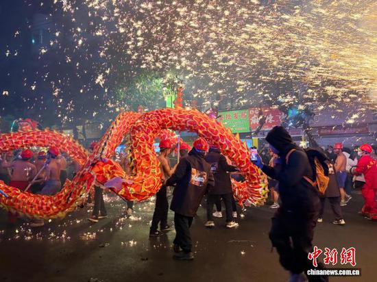 3月3日晚，贵州台江县城，民众在观看和拍摄苗族舞龙嘘花民俗活动。