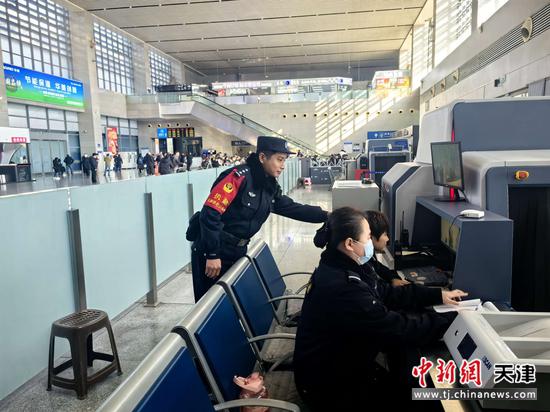 图为北京铁路公安局天津公安处沧州西站派出所民警在督导安检工作人员对所有过检物品严格审查。（北京铁路公安局天津公安处供图）