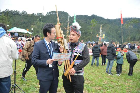 图为“双语”普法人员穿梭于人群中，用苗语向群众面对面普法。刘立立 摄