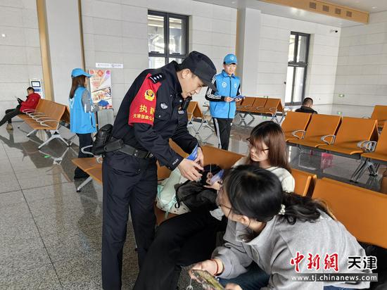图为北京铁路公安局天津公安处沧州站派出所民警联合铁路客运职工、大学生志愿者在站区向旅客群众开展反诈宣传，民警手持宣传册讲解法律知识，旅客认真倾听。（北京铁路公安局天津公安处供图）