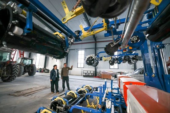 2026年3月6日，博乐市苏博物流园内，博乐市沃浩农机商贸有限公司员工（左）向农户介绍农机。于苏甫·艾尼 摄