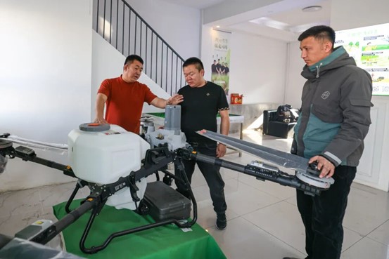 2026年3月6日，博乐市苏博物流园内，博乐市锐疆农业科技有限公司员工（左一）向客户介绍植保无人机。于苏甫·艾尼 摄