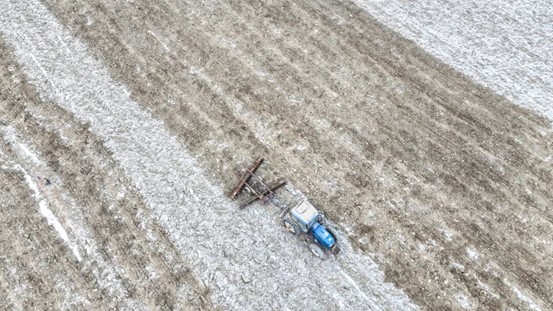 2026年2月28日，在精河县茫丁乡北地东村春小麦地里，大型拖拉机正在耕地。赛永杰 摄