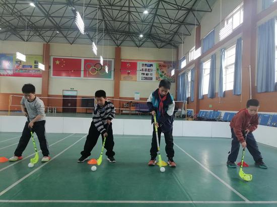 西夏区实验小学学生练习软式曲棍球。