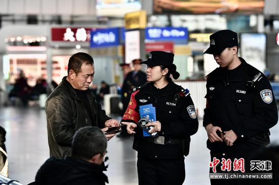 图为北京铁路公安局天津公安处天津站派出所民警在向旅客开展反诈宣传。(北京铁路公安局天津公安处供图)