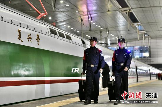 图为复兴号动集列车旁，青年乘警步履铿锵，以藏蓝身影筑牢旅途防线，守护春运旅客出行平安。（北京铁路公安局天津公安处供图）