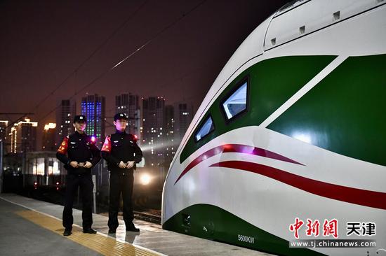 图为城市夜色里，动集列车车头旁，两名乘警身姿挺拔，用坚守为每一趟夜间列车保驾护航。（北京铁路公安局天津公安处供图）