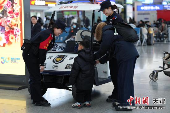 图为北京铁路公安局天津公安处天津站派出所民警在亲切的和小朋友交流。（北京铁路公安局天津公安处供图）