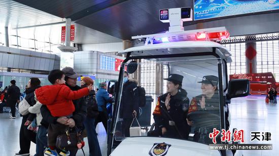 图为北京铁路公安局天津公安处天津站派出所民警热情回答旅客疑问。(北京铁路公安局天津公安处供图)