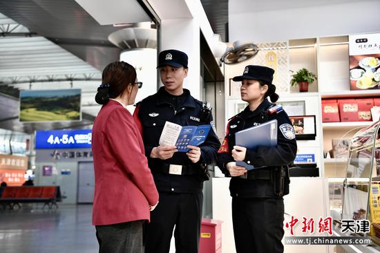 图为北京铁路公安局天津公安处天津站派出所民警在商铺内向工作人员开展反诈宣传。（北京铁路公安局天津公安处供图）