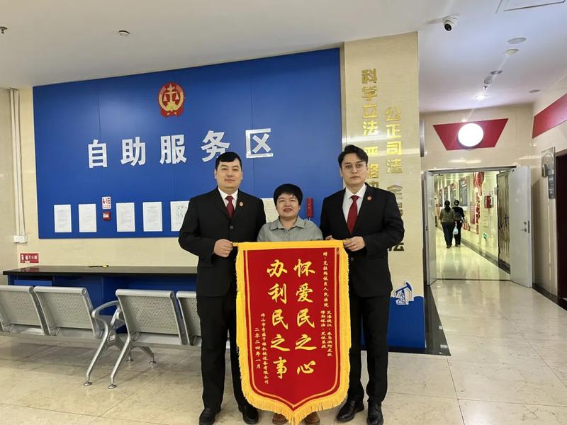 一起民事案件当事人为艾海提江·朱马洪阿皮孜法官和穆斯塔法·艾依来提（右一）送来锦旗。张安琪 摄