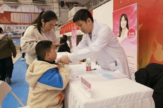 宝妈带孩子做健康检查。（图片由北京市援疆和田指挥部提供）