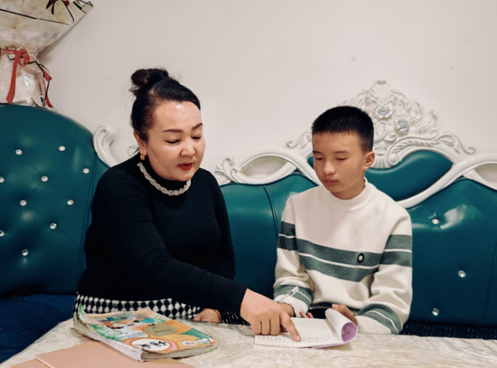 阿依夏木古丽为邱硕浩辅导作业。古丽阿亚提 摄e