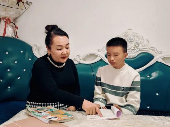 阿依夏木古丽给邱硕浩辅导作业。古丽阿亚提 摄